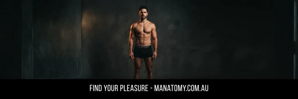 A man in black trunks standing against a dark plaster wall, above a Find Your Pleasure banner.