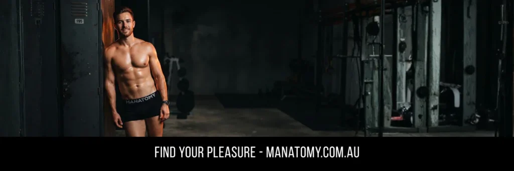 A man leaning in a doorway at the edge of a dark gym, above a Find Your Pleasure banner.